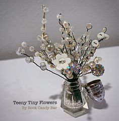 a vase filled with flowers and pearls on top of a table