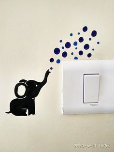 an elephant is throwing confetti into the air from a light switch cover on a wall