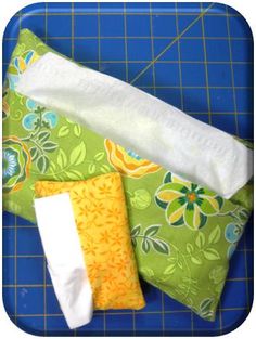 three pieces of fabric sitting on top of a blue cutting board next to each other