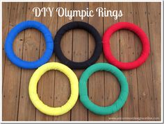 four different colored rings sitting on top of a wooden floor with the words diy olympic rings