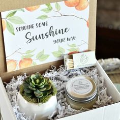 an open box with some candles and a succulent in it that says sending some sunshine you're way