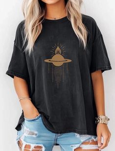 This Celestial Saturn Cross Tee is a boho-inspired shirt featuring the mount of Saturn planet design. Made with Comfort Colors fabric, this unisex Garment-Dyed Tee provides a relaxed fit and a crew neckline, making it perfect for casual and semi-formal settings. Ideal for those who love celestial designs, this tee is great for everyday wear and can be accessorized for a unique touch. Perfect for astrology enthusiasts and those who appreciate ethically sourced US cotton fabric. Great for holidays, celebrations, and occasions that celebrate the cosmos. Product features - Available in multiple sizes from S to 4XL - Double-needle stitching for durability - Garment-dyed fabric for soft color and texture - Ethically sourced US cotton - Relaxed fit and crew neckline for comfort and style Care ins Bohemian Relaxed Fit Crew Neck Top, Bohemian Relaxed Fit T-shirt For Festival, Bohemian Tops With Screen Print, Relaxed Fit, Bohemian Tops With Screen Print And Relaxed Fit, Bohemian Cotton Tops With Graphic Print, Bohemian Graphic Print Shirt For Festivals, Bohemian Shirt With Graphic Print And Relaxed Fit, Bohemian Shirt With Relaxed Fit And Crew Neck, Planet Shirt