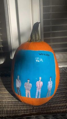 an orange pumpkin decorated with people painted on it