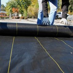 two men working on an outdoor trampoline