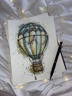 a watercolor painting of a hot air balloon on white paper with string lights around it