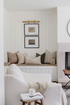 a living room filled with furniture and a clock on the wall above it's fireplace