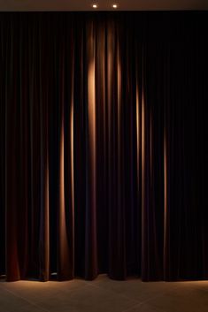 an empty room with dark curtains and lights