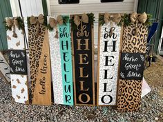 several wooden signs with bows on them sitting in front of a door and some grass