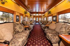 the inside of a train car with couches and tables on each side of it