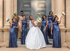 a group of women standing next to each other in front of a door holding bouquets