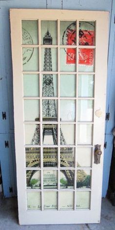 an open door with the eiffel tower painted on it's glass panels