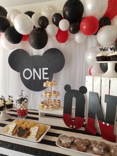 a mickey mouse themed birthday party with balloons and desserts