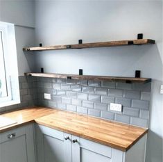 an empty kitchen with wooden counter tops and gray tile backsplashes on the wall