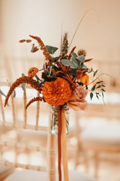 a vase filled with flowers sitting on top of a table next to a white chair