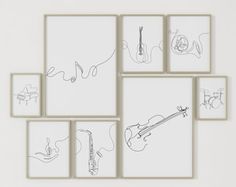 a white wall with several drawings on it and one has a guitar in the middle