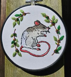 a small embroidered mouse on a wooden surface