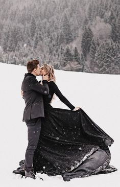 a man and woman are kissing in the snow