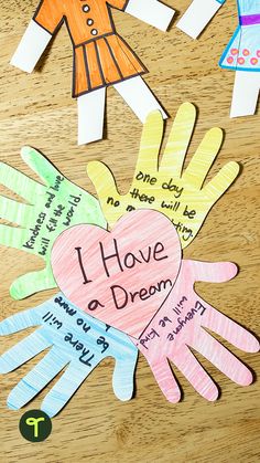 children's handprinted paper cut out to spell i have a dream on a wooden table