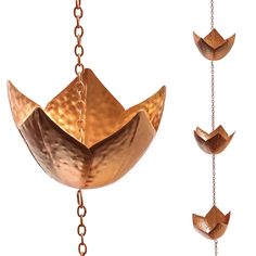 three pieces of metal hanging from chains, one with an origami boat on it