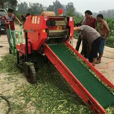 two men are working on a machine that is being used to cut grass from the ground