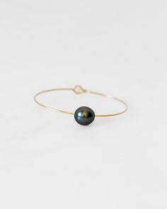 Crafted from hammered 14K gold wire, this signature cuff bracelet showcases a Tahitian pearl. Produced by the Black Lip Oyster, these cultured seawater pearls were originally cultivated in Tahiti and are considered symbols of wisdom, independence, and strength.