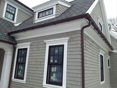 a gray house with white trim and windows