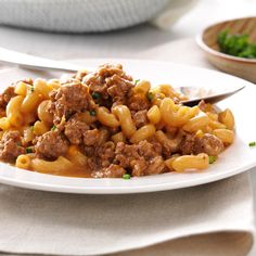 a white plate topped with pasta and meat