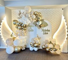 balloons are arranged in the shape of an angel with gold and white decorations on it