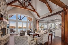 a living room filled with furniture and a fire place in front of a large window