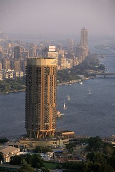 an aerial view of a tall building in the middle of a large body of water