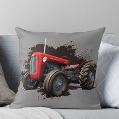 a red tractor throw pillow sitting on top of a couch