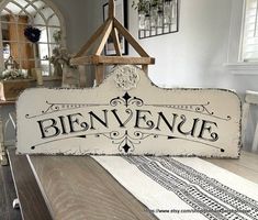 a wooden sign that says bien venque sitting on top of a table