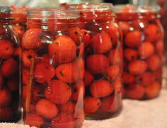 there are many jars filled with cherries on the table