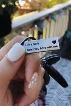 someone is holding up a fake ring that says drive safe, i need you here with me