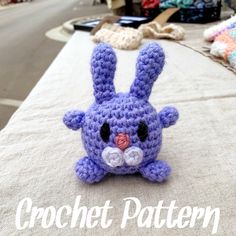 a crocheted blue bunny sitting on top of a table