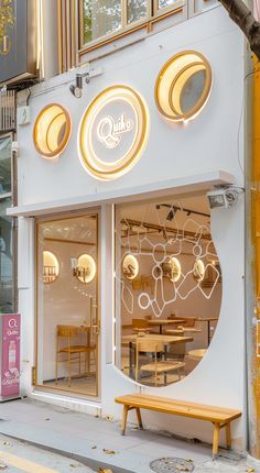 the outside of a restaurant with round windows and circular lights on it's side