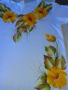 a white shirt with yellow flowers painted on it