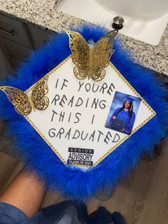 a blue and gold graduation cap that says if you're reading this i graduated