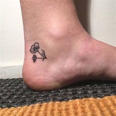 a person with a small flower tattoo on their foot