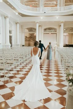 a bride and groom walking down the aisle at their wedding ceremony in an old building