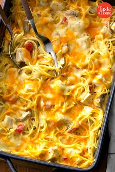 a casserole dish with chicken, cheese and noodles in it on a wooden table