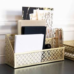 an organized desk with gold and black accessories