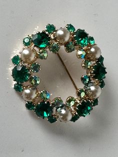 "A stunning vintage pearl with emeral green and aurora borealis rhinestone chatons layered wreath brooch. Two tiered brilliants. The aurora borealis stones reflect gold, blue and butter yellow. Gold plated setting. Though unsigned it is reminiscent of Montreal mid-century jewelers Continental, Jayflex and Sherman. The brooch measures 1 1/2 inches in diameter and 1/4\" deep incl. of pin mechanism In excellent vintage condition. Prices are listed for Canada and USA only but if you wish to have the Wedding Jewelry Bride, Jewelry Bride, Of Montreal, Butter Yellow, Vintage Pearl, Christmas Pins, Green Crystal, Vintage Pearls, Jewelry Wedding