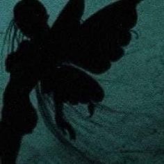 the silhouette of a woman with wings is shown in this dark photo, and appears to be holding something