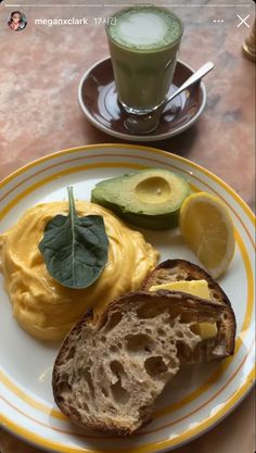 an avocado and bread on a plate next to a cup of green tea