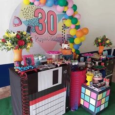 there is a table that has many items on it and balloons in the shape of numbers