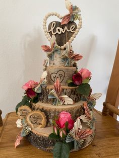 a three tiered cake decorated with flowers and hearts