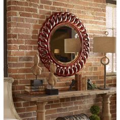 a mirror on a brick wall above a fireplace