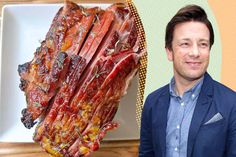 a man standing next to a large piece of meat