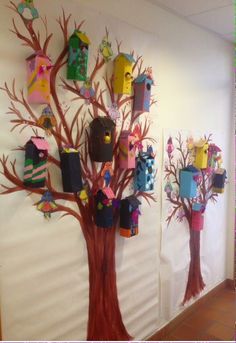 the tree is decorated with colorful paper houses and birdhouses on it's branches